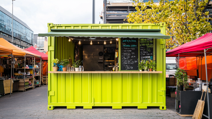 10ft lime green container office in a busy marketplace with an awning