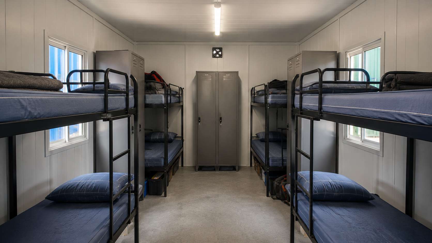Interior of a 20×20 ft bunkhouse cabin with two rows of bunk beds and lockers.