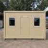 Sandstone beige 20×20 ft bunkhouse cabin front view with central door and two windows.