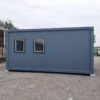 Steel blue 20×20 ft bunkhouse cabin side view showing insulated panel wall and windows.