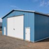 Blue commercial shed showing its long clad side wall and large white roller-shutter door.
