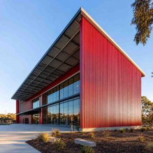 Red-clad prefabricated commercial building with a glazed front and mono-slope roof, built by SAMAN.