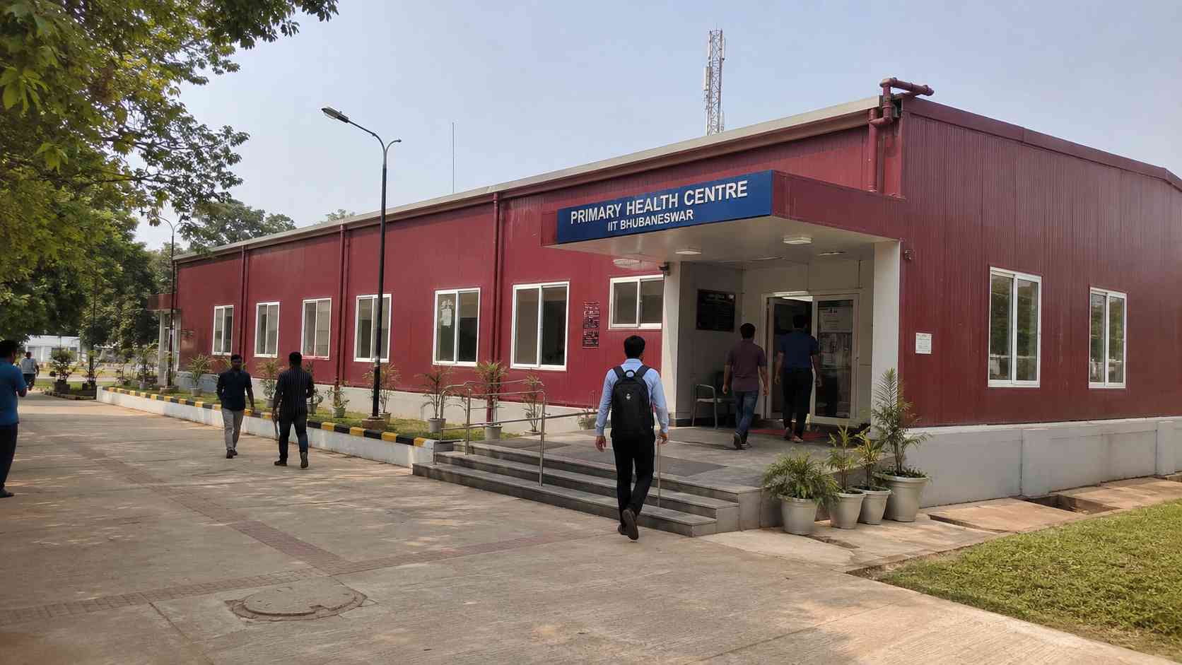 Burgundy-red prefabricated institutional building such as a clinic or school block, in use.