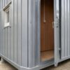 Close-up of steel grey MS sheet cladding seam and MD board interior at the door edge.