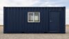 Navy blue container building front, 20-foot face with single door and window.