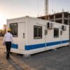 Container office cabin three-quarter angle view showing AC unit electrical box and corrugated steel panels