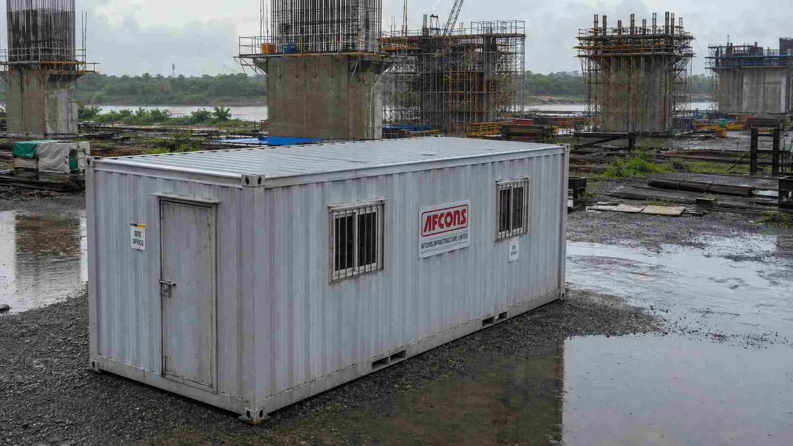 SAMAN container unit at a bridge construction site after monsoon rain with weathered exterior.