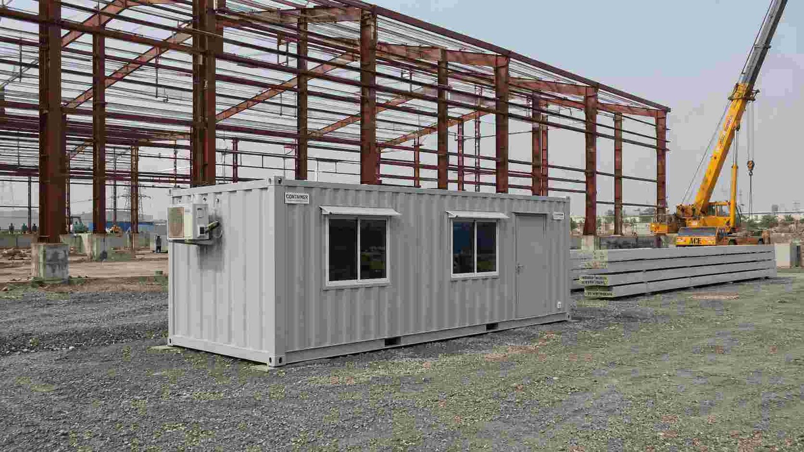 SAMAN container office unit at an industrial warehouse construction site in mid-morning light.