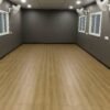 Empty porta cabin interior with wooden flooring and multiple windows.