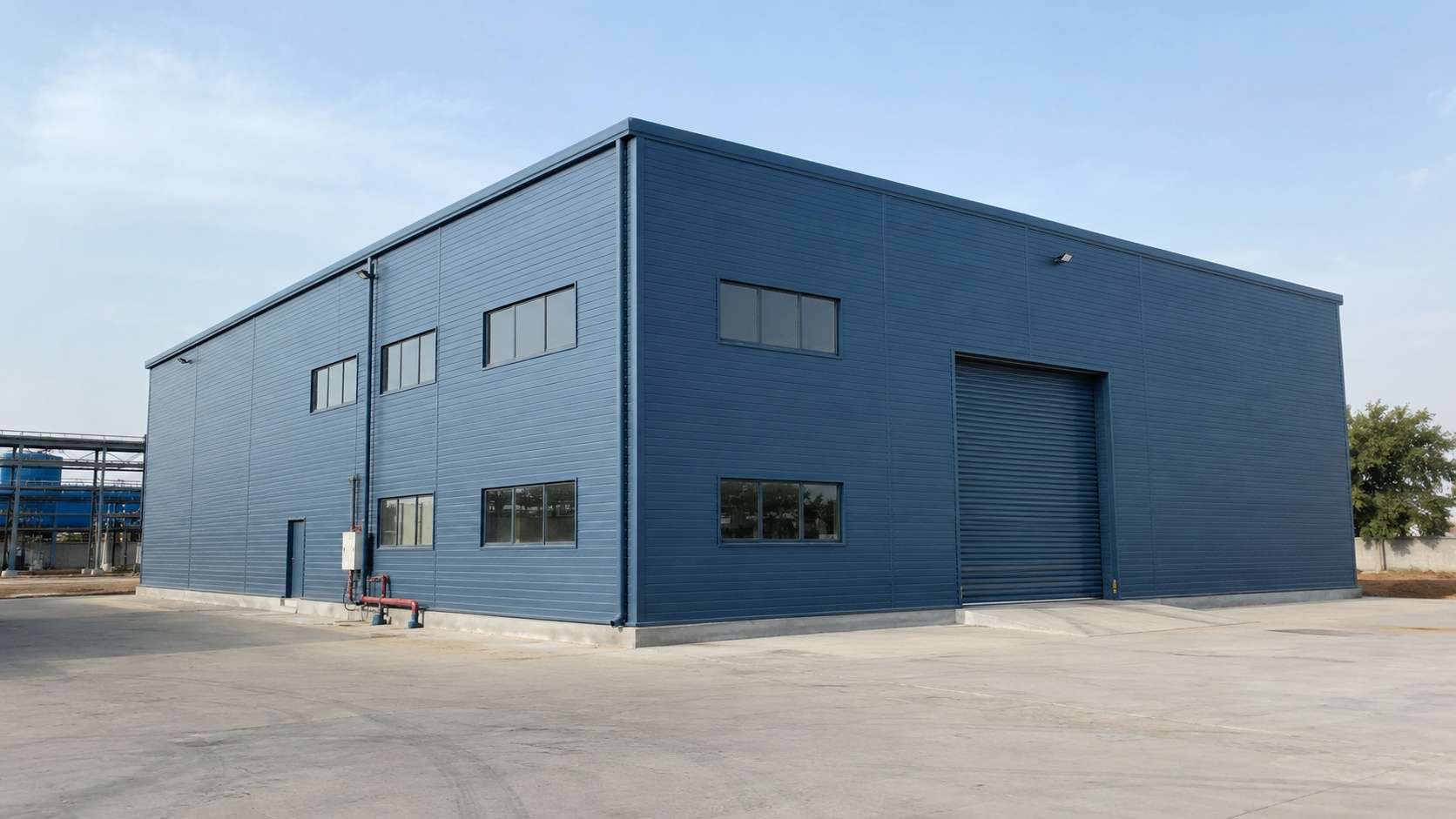 Steel-blue engineered building on a manufacturing estate showing the sealed PUF-panel envelope.