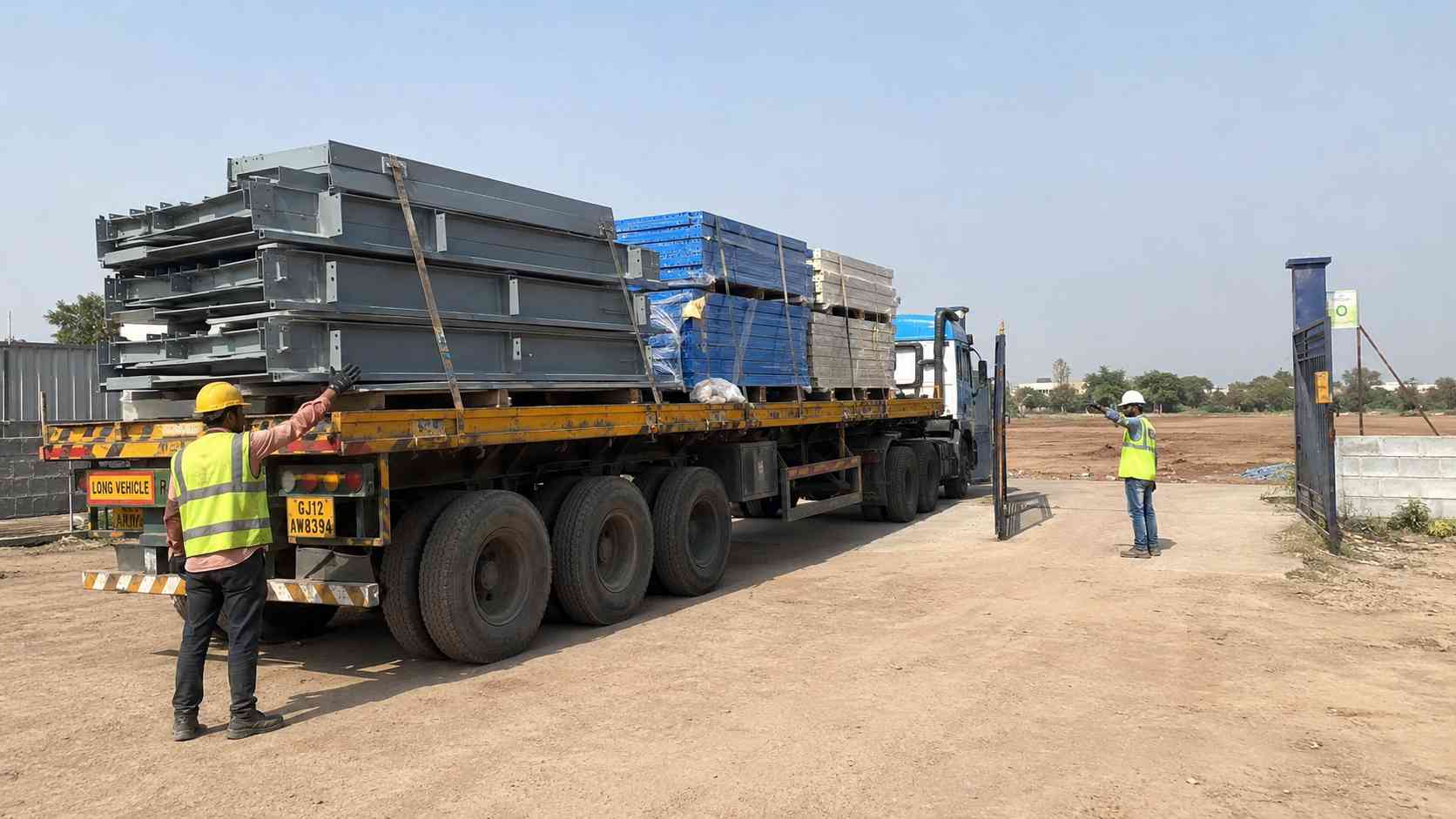 Fabricated engineered metal building components delivered on a flatbed trailer to an Indian site