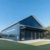 Navy-blue engineered steel building with a front entrance canopy and glazed doors