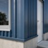 Close-up of blue PUF panel cladding and corner flashing on an engineered steel structure