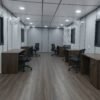 Grey porta cabin interior with desks and chairs for portable workspace solutions.