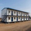 Side view of a single SAMAN two-storey labor accommodation dormitory block at a project site.