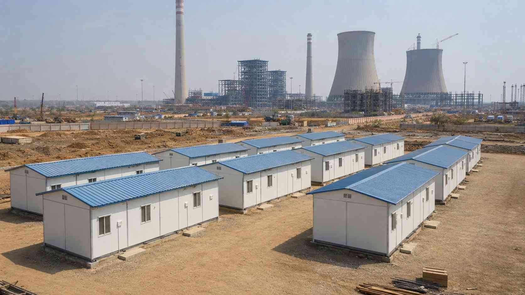 SAMAN labor cottages at an Indian thermal power plant construction site with cooling towers and structural steel visible in background