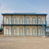 SAMAN labor shed in G+1 two-storey configuration with 12 worker room doors and external steel staircase