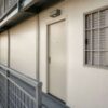 Close-up of a SAMAN labor shelter walkway, handrail, and room door on the first floor