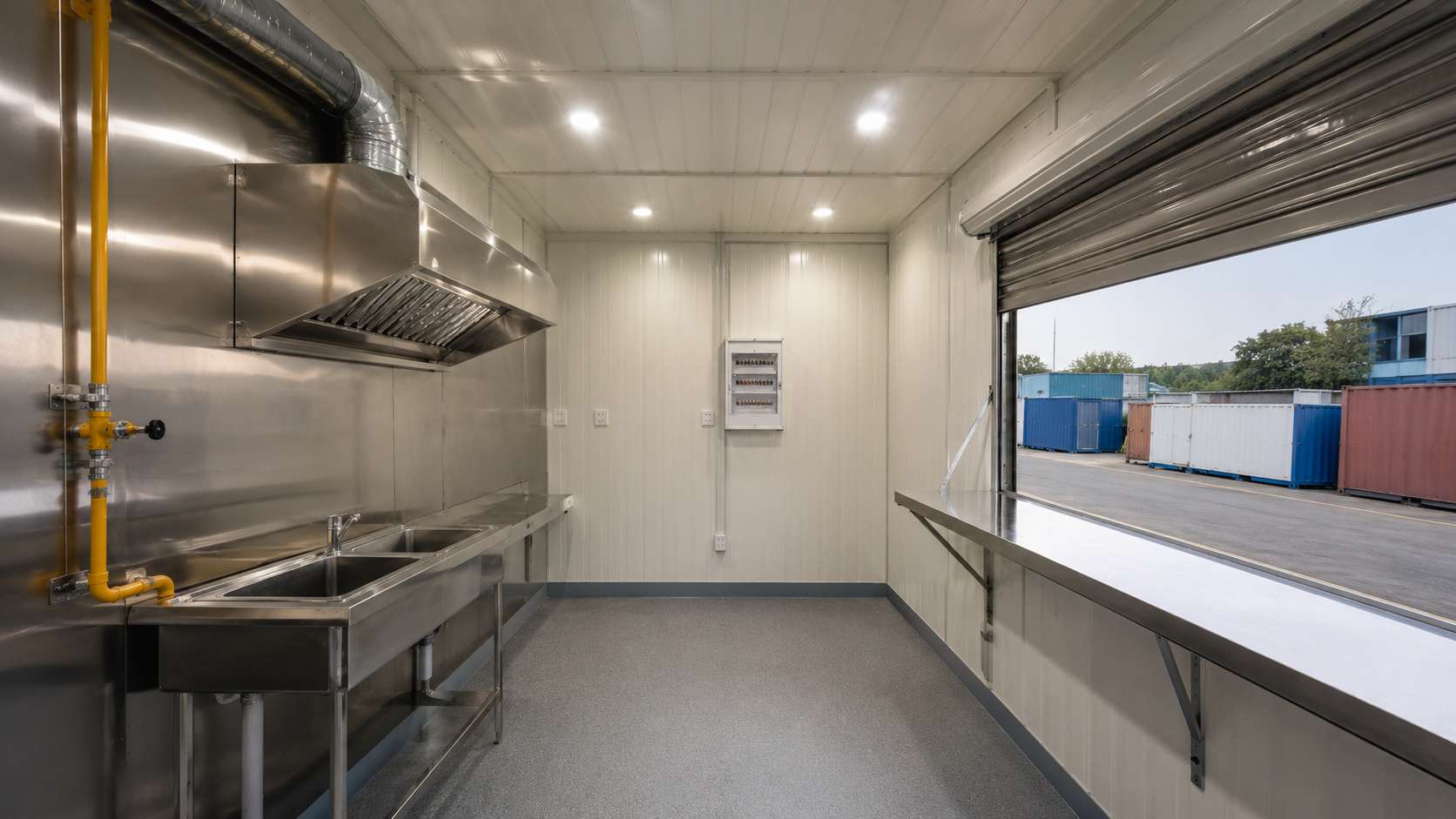 Interior of a 10×10×8 ft SAMAN mobile container cafe — kitchen wall with exhaust hood, LPG inlet, sink, and service window