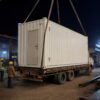 Mobile office container loaded on flatbed truck for relocation