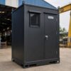 Graphite black mobile toilet side view showing fork pockets and crane lifting lugs