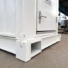 Close-up of a white mobile toilet base showing crane lug and forklift pocket