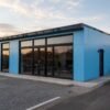 Blue prefab office building with glass front elevation