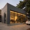 Dark grey prefab commercial building with glass showroom front