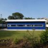 ide view of a royal cobalt blue modern container home showing clean lines and ribbon windows.
