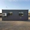 Slate Charcoal modular container office side elevation with electrical conduit stub-outs and ISO corner castings visible.