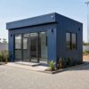 Navy Blue 20×15×11 ft modular office building with tall glass entrance on a commercial plot.