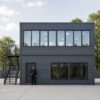 Side elevation of two-storey modular portable office in slate charcoal grey showing external staircase and glass upper floor