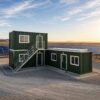 Hybrid stacked container office configuration at a solar farm project, forest green exterior with white trim.