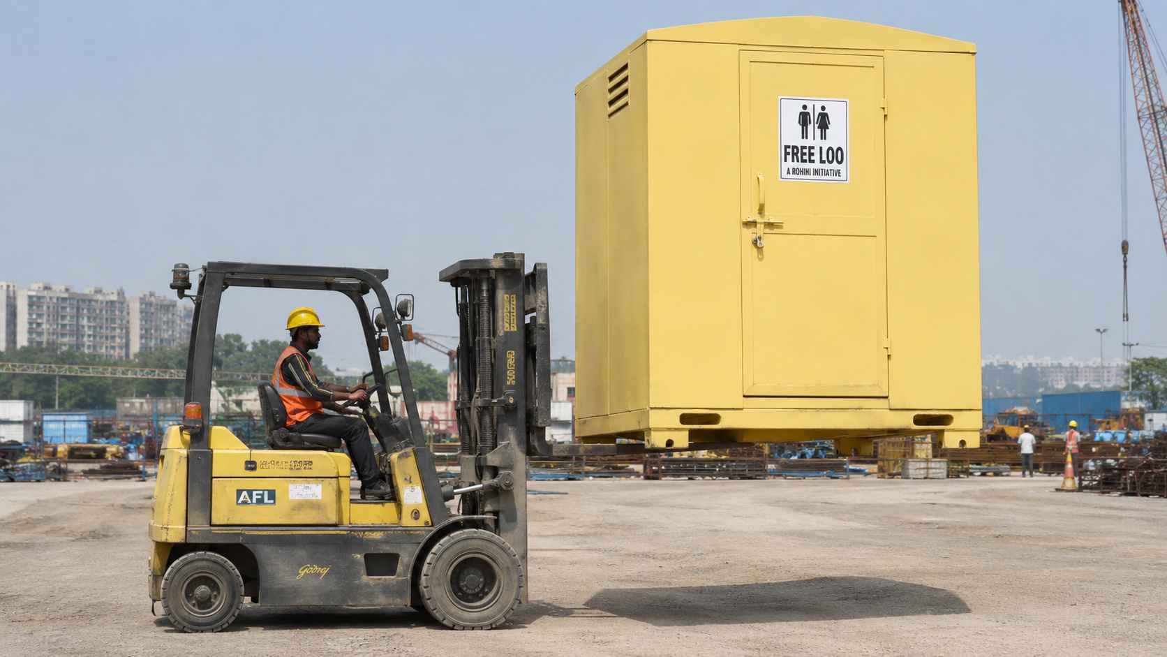 Forklift lifting a movable toilet cabin by its base points to relocate it on site