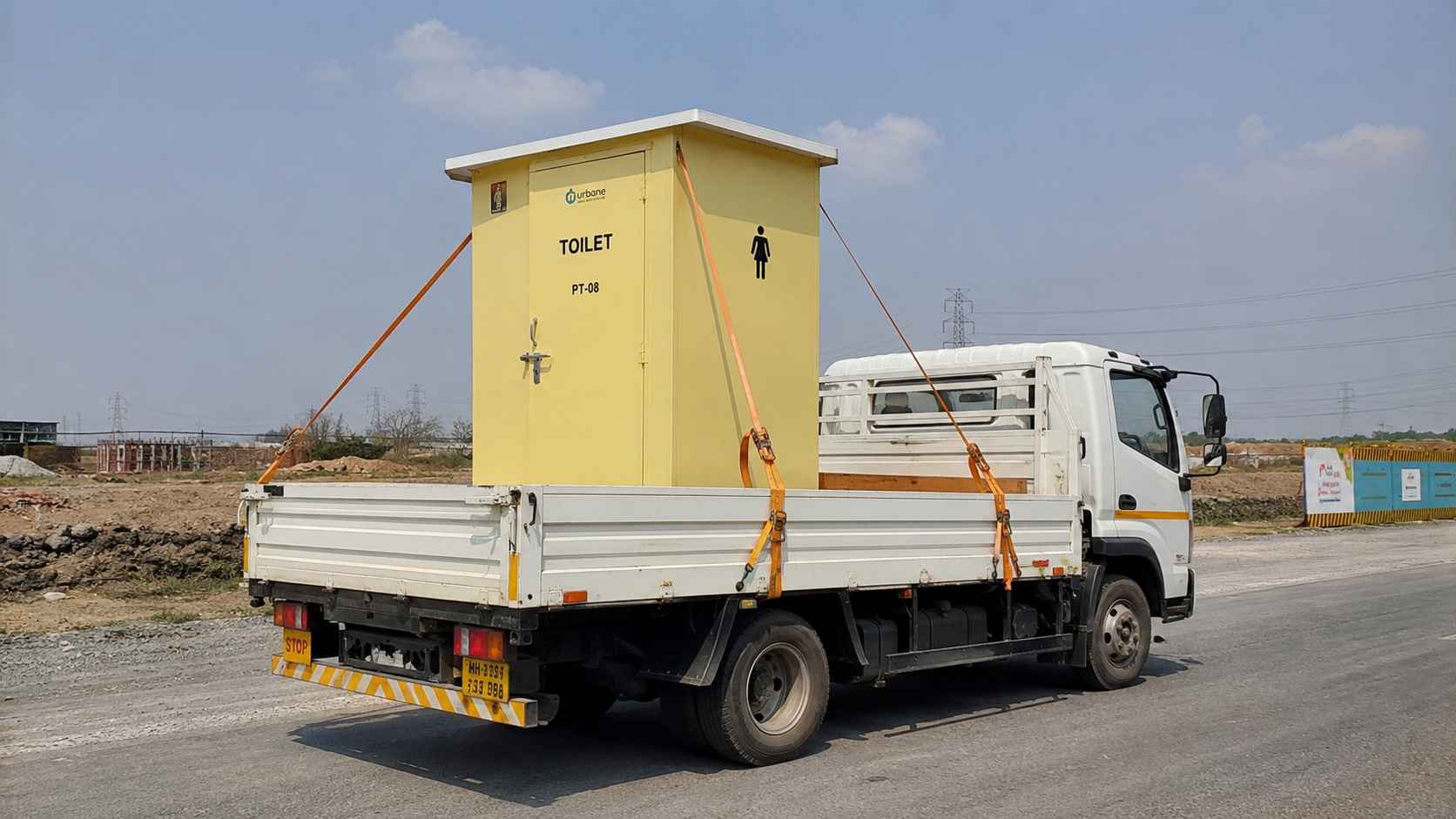 Compact movable toilet cabin strapped on a flatbed truck for a site-to-site move