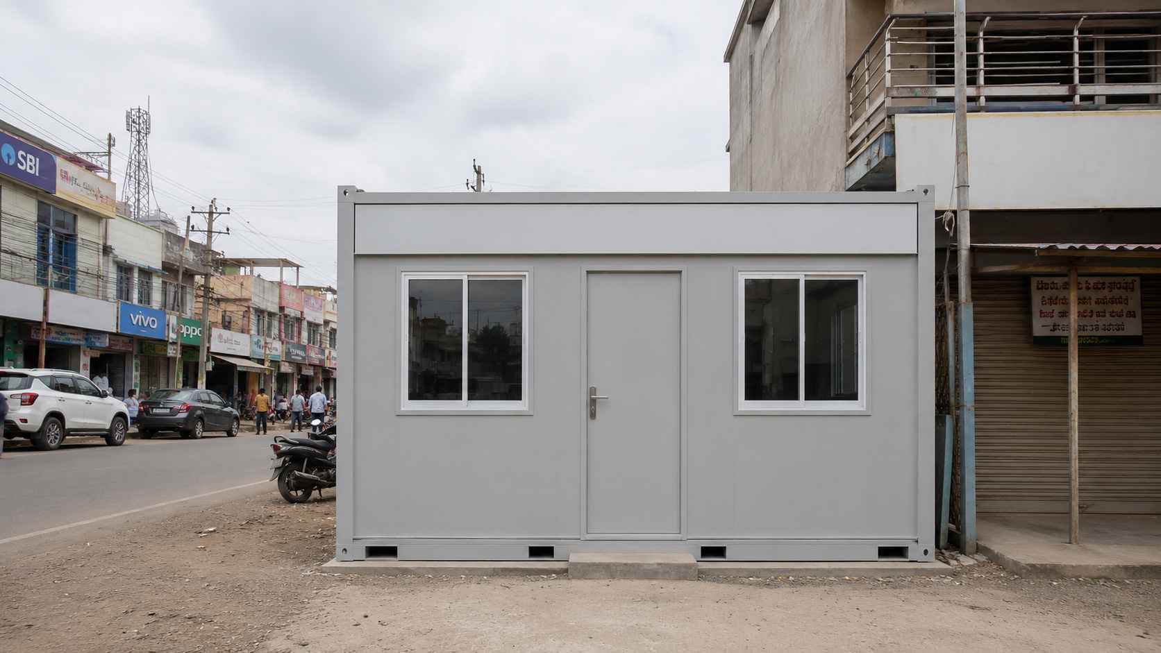 Pearl Grey office cabin used as a storefront-office on an Indian Tier-2 commercial street, adjacent shops and pedestrians.