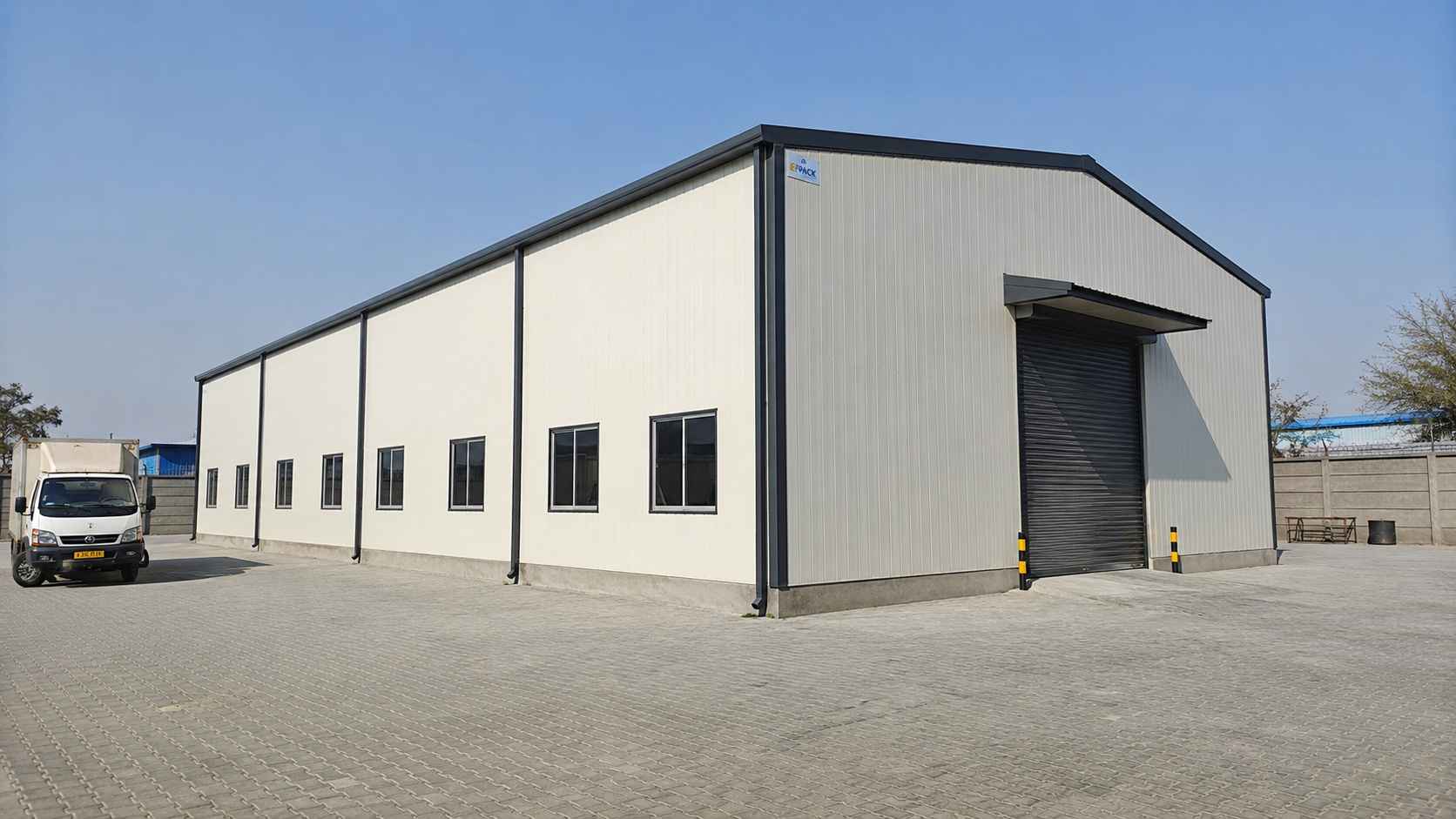 Completed 60×30 ft off-white PEB steel building on a finished Indian industrial compound
