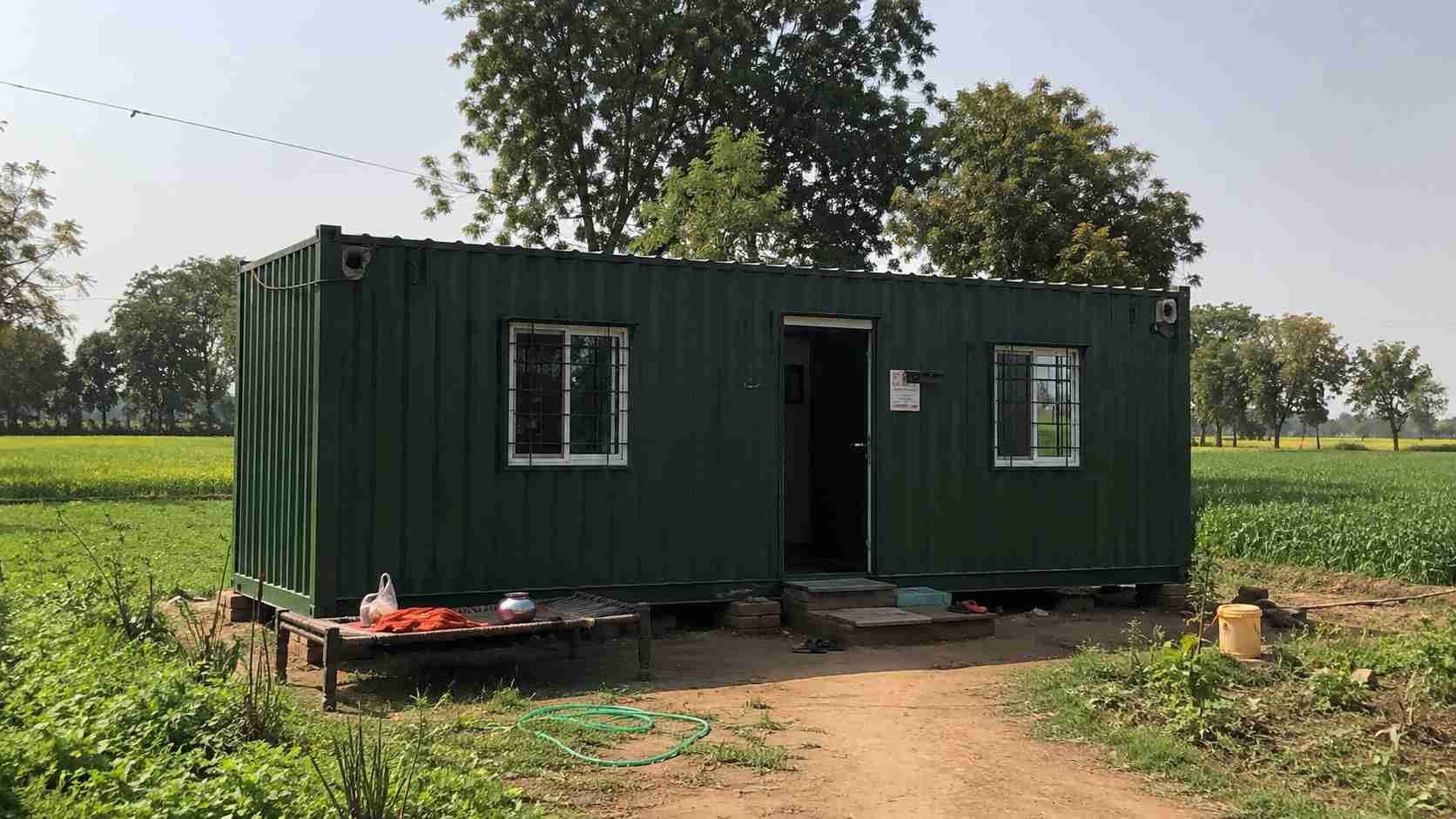 Forest green porta cabin house on a farm, used as a rural home.