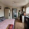 Interior of a porta cabin house furnished with a bed and compact kitchen, used as a home.