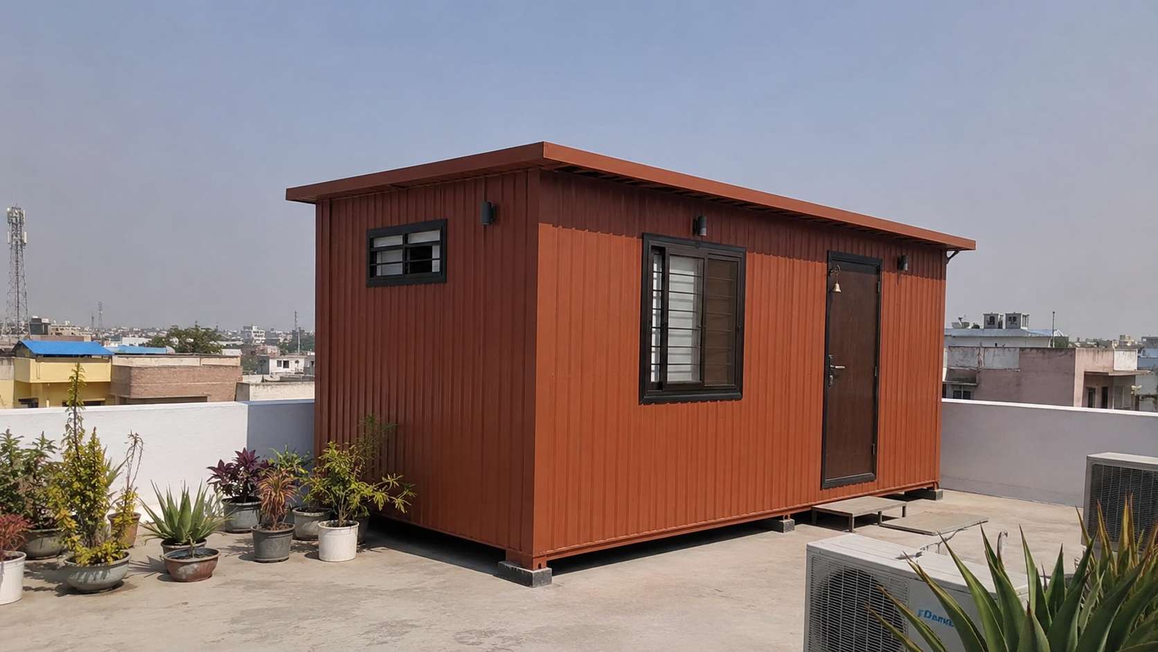 Brick terracotta porta cabin house placed on a building rooftop terrace as extra living space.