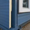 Close-up of a steel blue porta cabin house wall showing the insulated sandwich panel and steel frame.