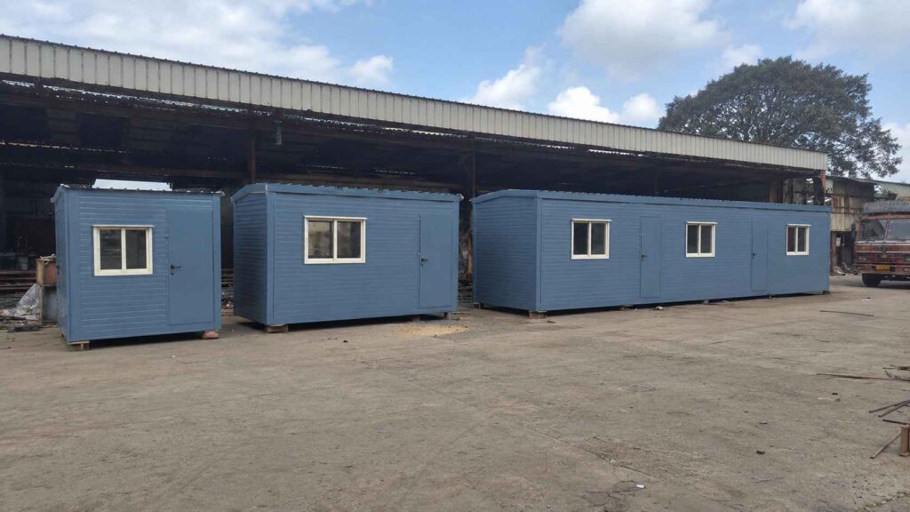 Steel blue porta cabins in 10×10, 20×10, and 30×10 sizes lined up at a manufacturing yard.