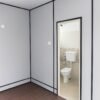 Porta cabin interior with grey walls and toilet attached