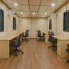Porta cabin interior with wooden finish, desks, and chairs for modular office use.