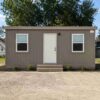 Warm taupe portable cabin house front view with central door and two windows