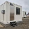 Pure White portable container offices arranged in formation showing entry door, welded access step, and RCC pad foundation.