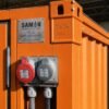Macro detail of numbered serial plate, ISO 1161 corner casting, and paired electrical socket on a Safety Orange unit.
