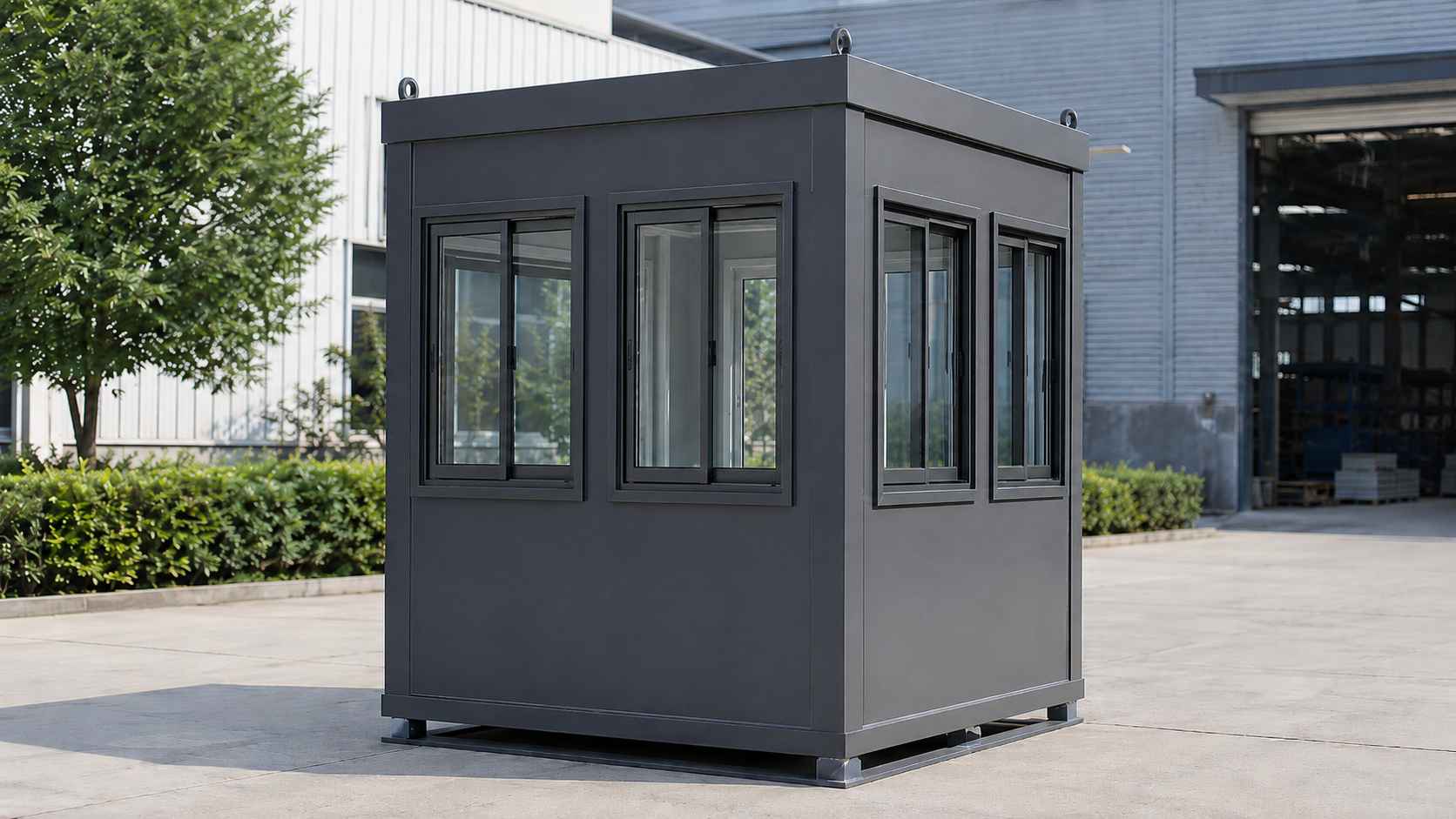 Wide view of charcoal portable security cabin showing four sliding windows across two visible faces.