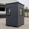 Slate charcoal portable security cabin with skid base, lifting eyes, and four sliding windows on display.