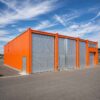 Bright orange storage building with grey doors